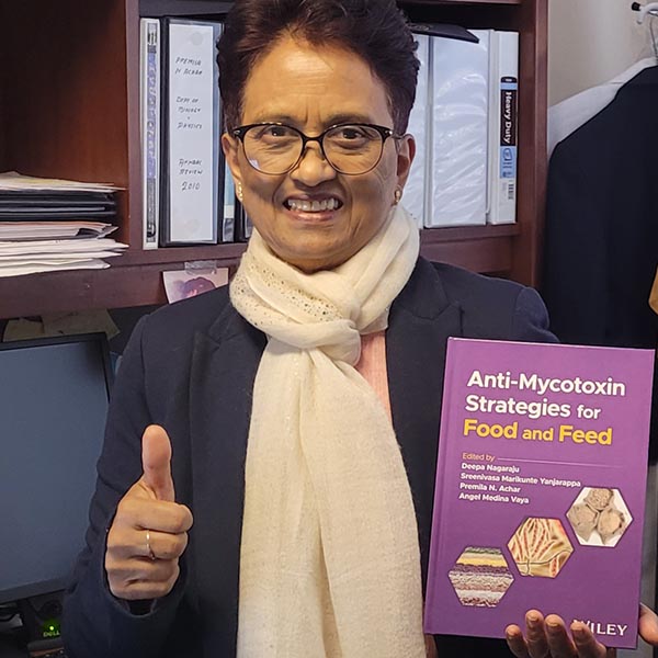 Photo of Premila Achar with her published textbook, Anti-Mycotoxin Strategies for Food and Feed.