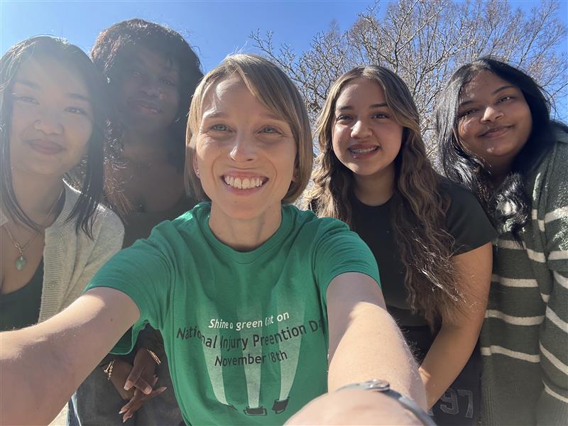 team members wearing green and smiling