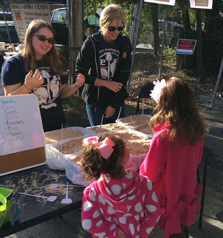 two KSU students showing excavation to two girls